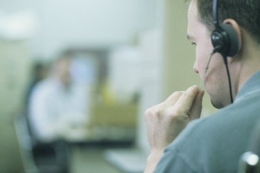 Phone salesman wearing headset in office