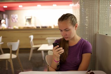 Girl reading email by phone