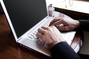 Hands of man typing on laptop