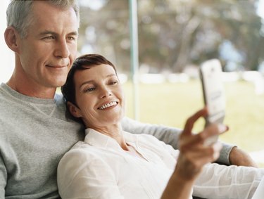 Mature Couple Sit Together Looking at a Mobile Phone