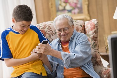 Young boy and his grandfather fighting over the remote control