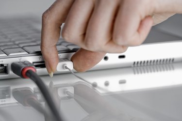 Hand with laptop computer with USB cords