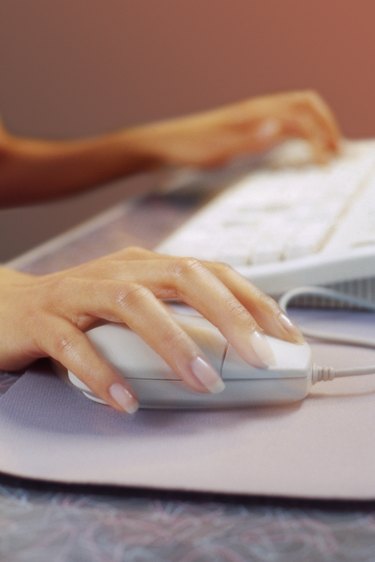 Female hands using computer mouse and keyboard