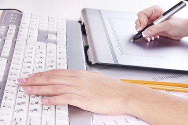 Female hand using graphics tablet on table close up