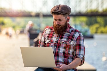 Trendy hipster young man with laptop
