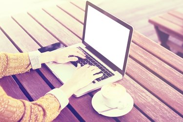 Girl with laptop, cell phone and cup of coffee