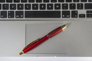 Ballpoint Pen Lying On Laptop