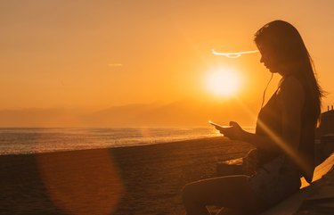 Young woman listen music on the beach