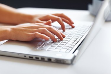 Businesswoman typing on laptop