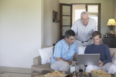 Father with his two sons looking at a laptop
