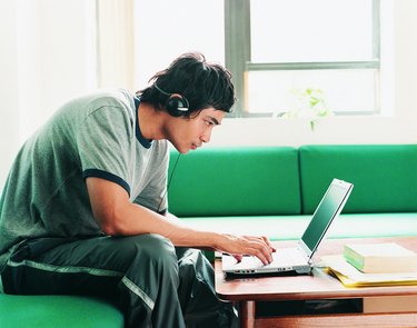 Asian Student Using Laptop at Home