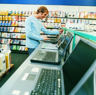 Young Man Looking at a Laptop in a Computer Shop