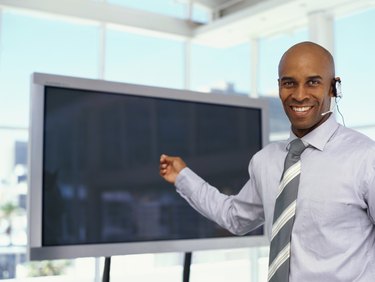 portrait of a businessman pointing to a projection screen at a seminar