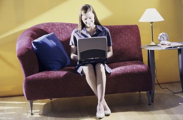 Young woman sitting on a couch using a laptop