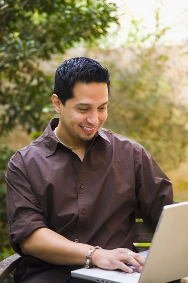 Man working on a laptop and smiling