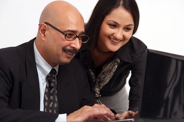 Businessman and businesswoman using a laptop