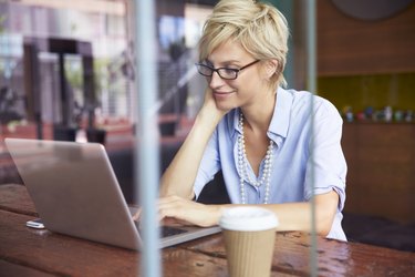 Businesswoman Working On Laptop In Coffee Shop
