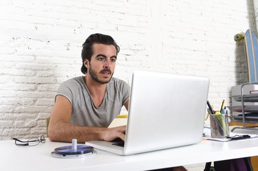 hipster student or businessman working with laptop computer at office