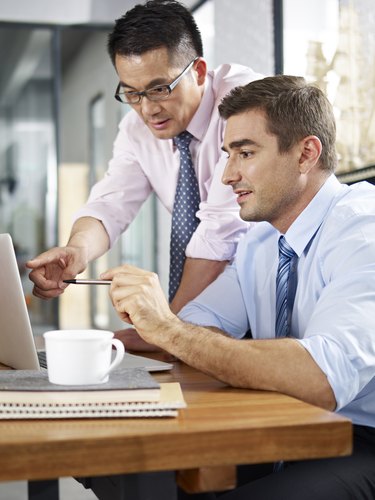 asian and caucasian businessmen working together in office