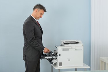 Businessman Fixing Cartridge In Printer Machine At Office