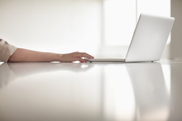 Close up of businesswoman's arm using her laptop in the office