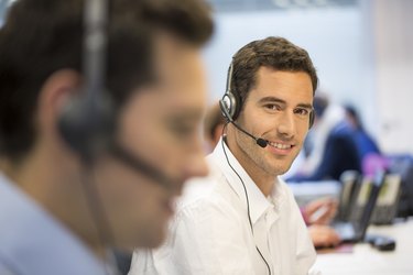 Businessman at office on the phone with headset, looking camera