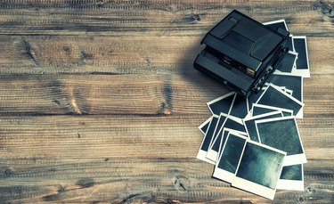 Polaroid photo frames and camera on rustic wooden background. retro style toned picture