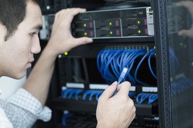 Young businessman holding and plugging in a computer cable