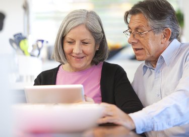 Senior couple using digital tablet at home