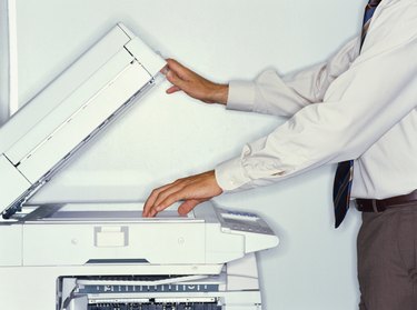 midsection view of a businessman operating a photocopier in an office