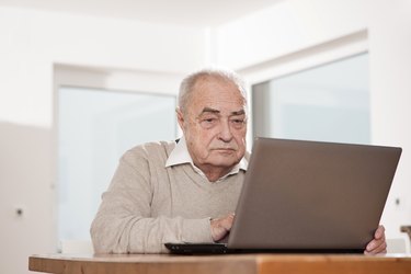 Senior man using laptop at table