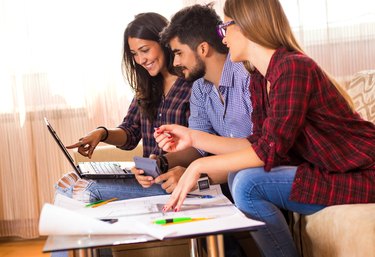 Three young architects working on a project.