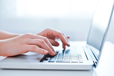 Woman's hands using laptop at the office