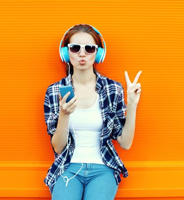 Pretty cool girl having fun and listens music in headphones