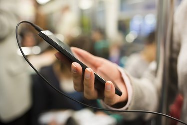 Woman listens to music with her cell phone in subway