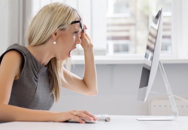 Shocked woman looking at computer screen with totally surprised look