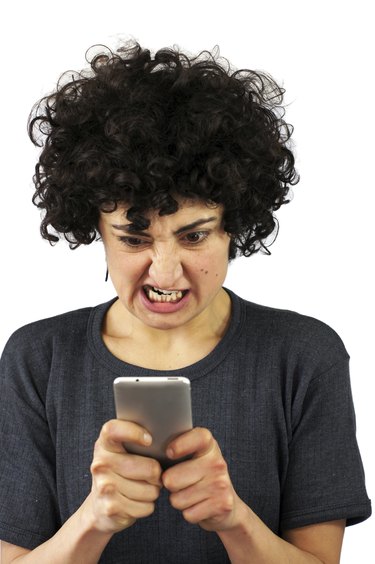Angry woman looks at her phone
