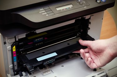 Man hand puts toner in the printer