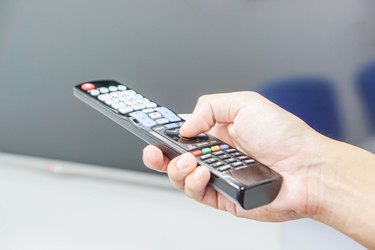 Turn on TV with remote control in hand