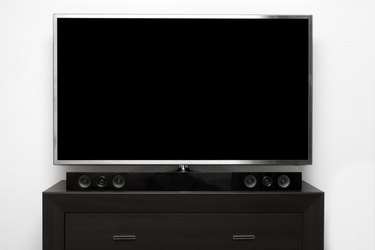 blank tv with stereo system on brown commode