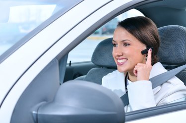 beautiful woman is safely talking phone in a car