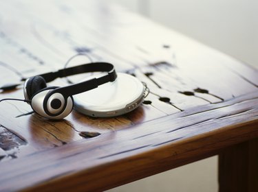 headphones and a personal stereo on a wooden table