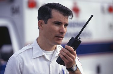 Paramedic talking into walkie-talkie in street