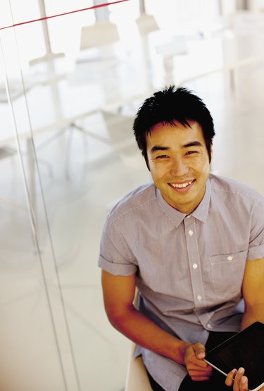 Portrait of smiling businessman using digital tablet in office