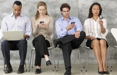 Four People Using Communication Equipment