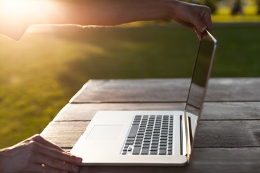 Man uses a laptop in the park