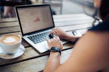 Woman at cafe working on her laptop