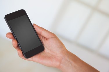 Womans hand holding black smartphone