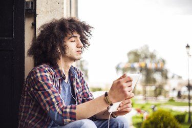 Young man listening music with digital tablet