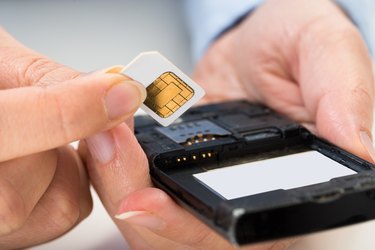 Person Hand With Sim Card And Mobile Phone